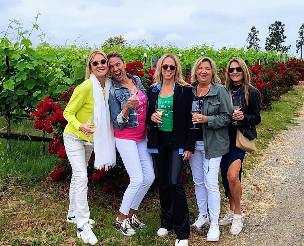 A group walking a vineyard path on a self-planned wine day